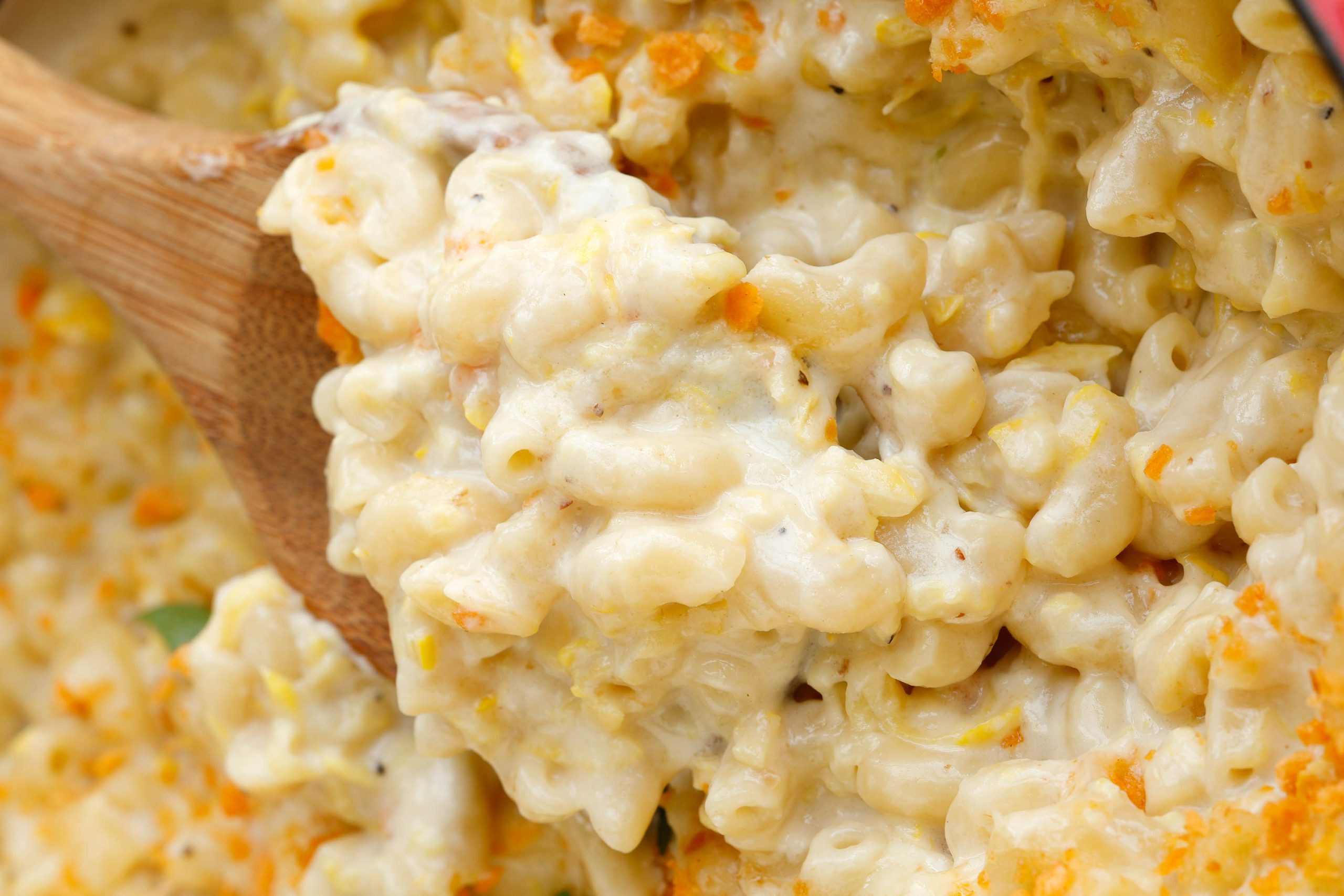 Horizontal image of large pan with mac and cheese with serving spoon.