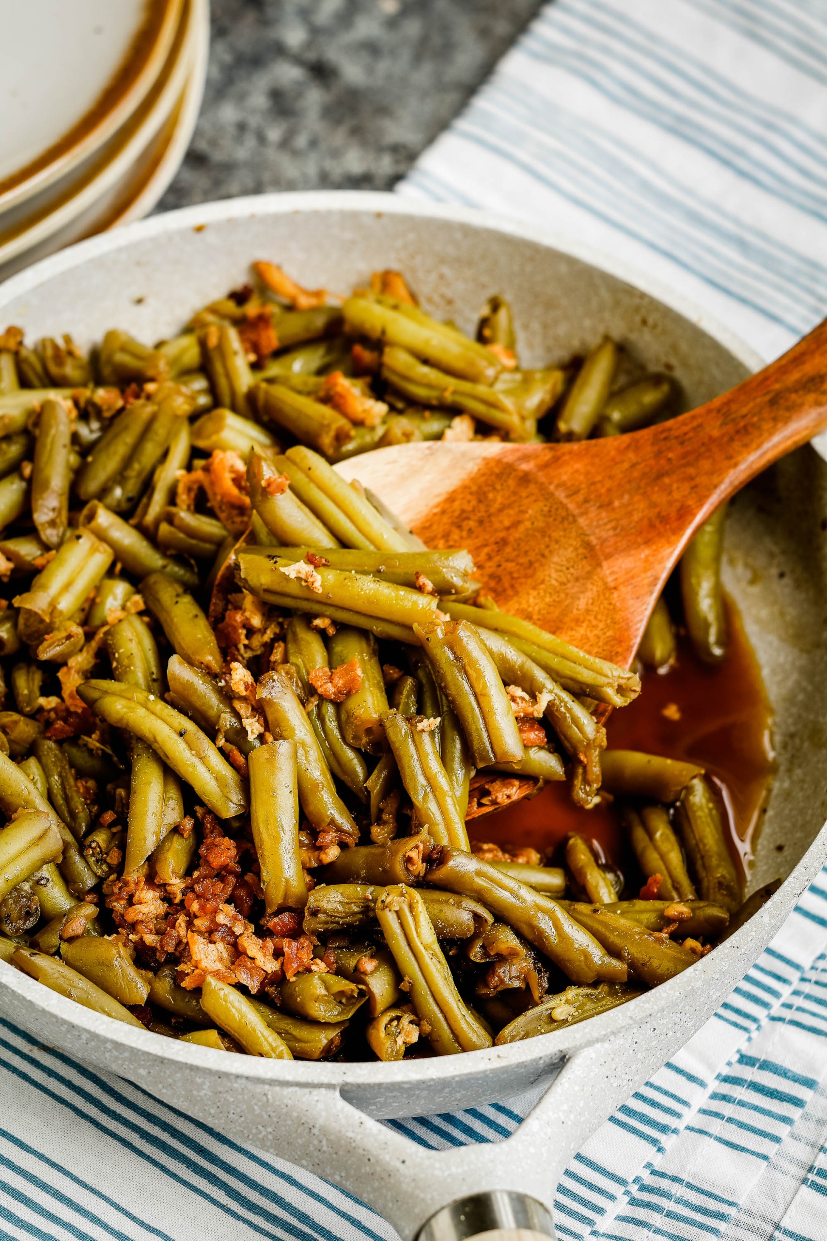 Vegetables being served with a wood spoon.