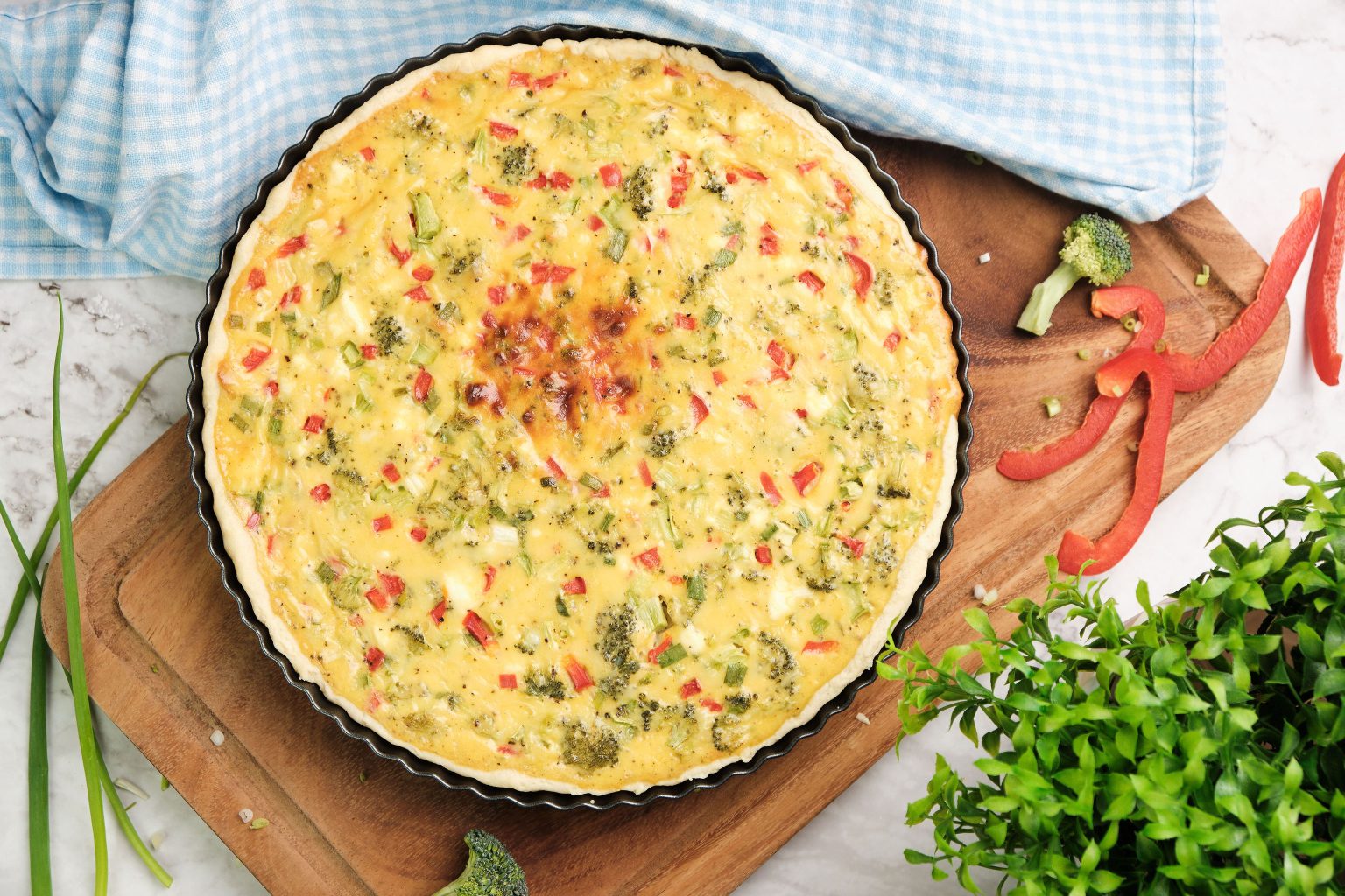 Whole veggie Quiche on a cutting board.