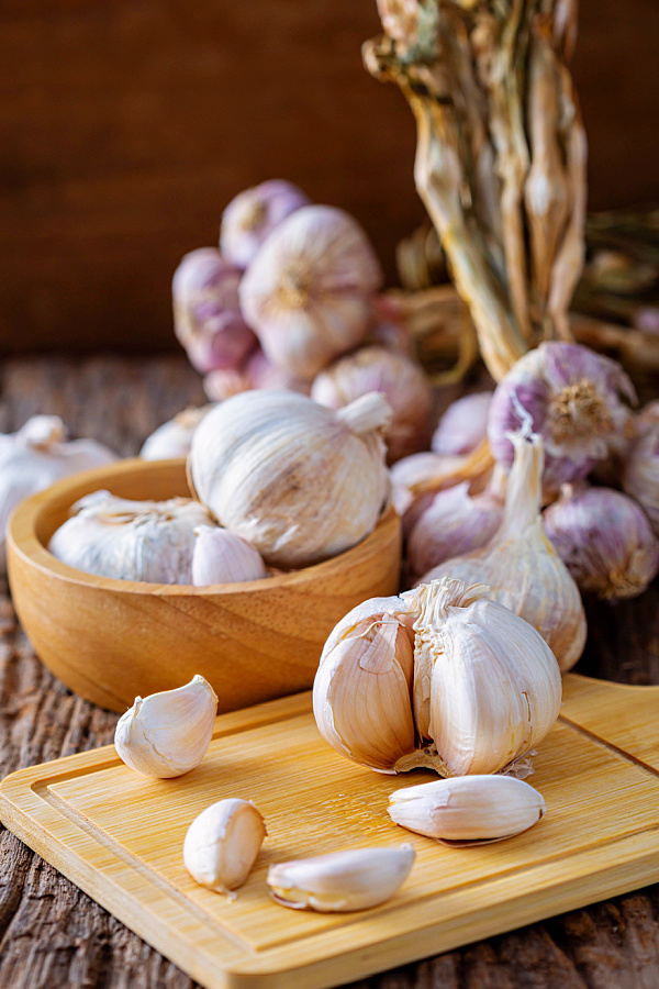 Piles of garlic on wood table.