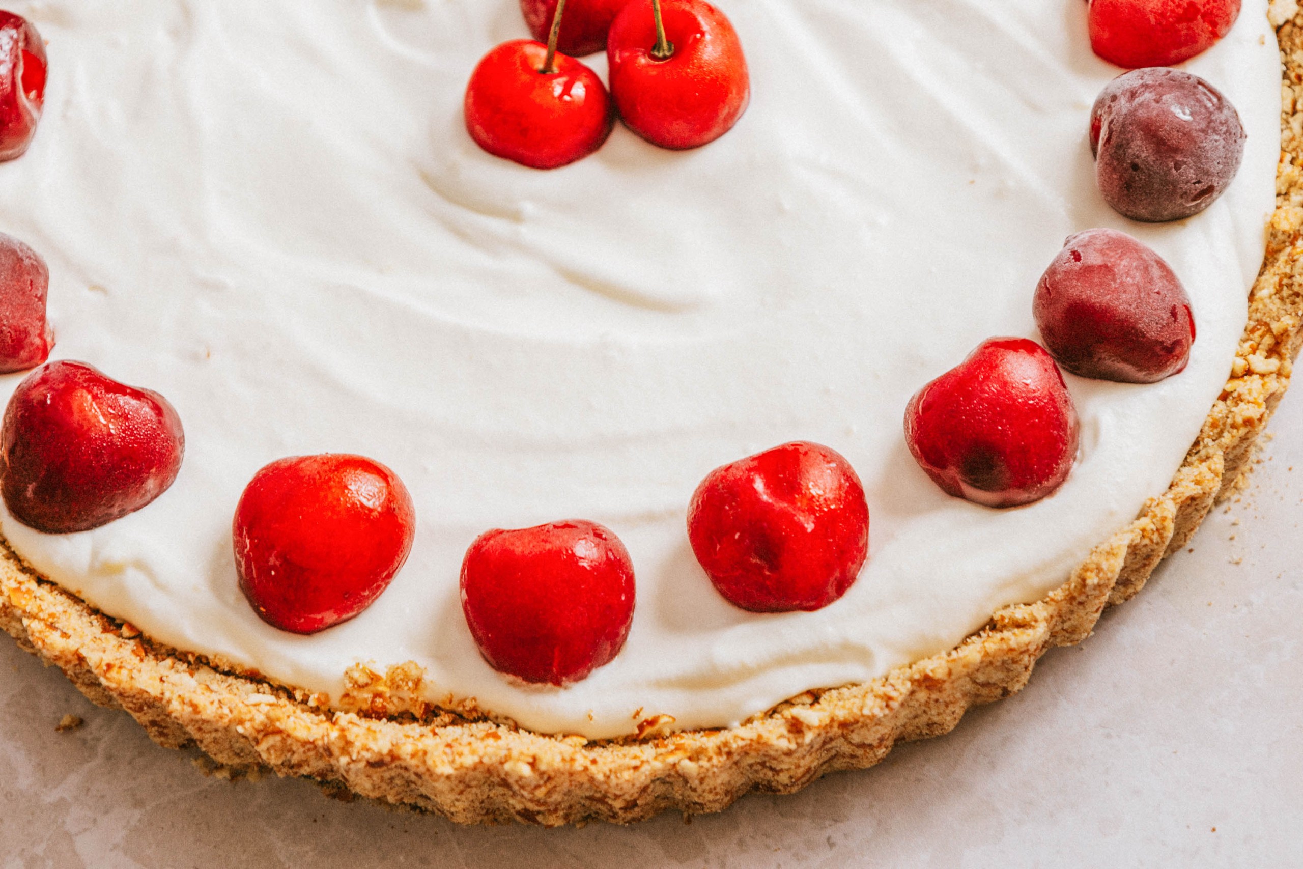 Mascarpone tart with cherries around the edges.