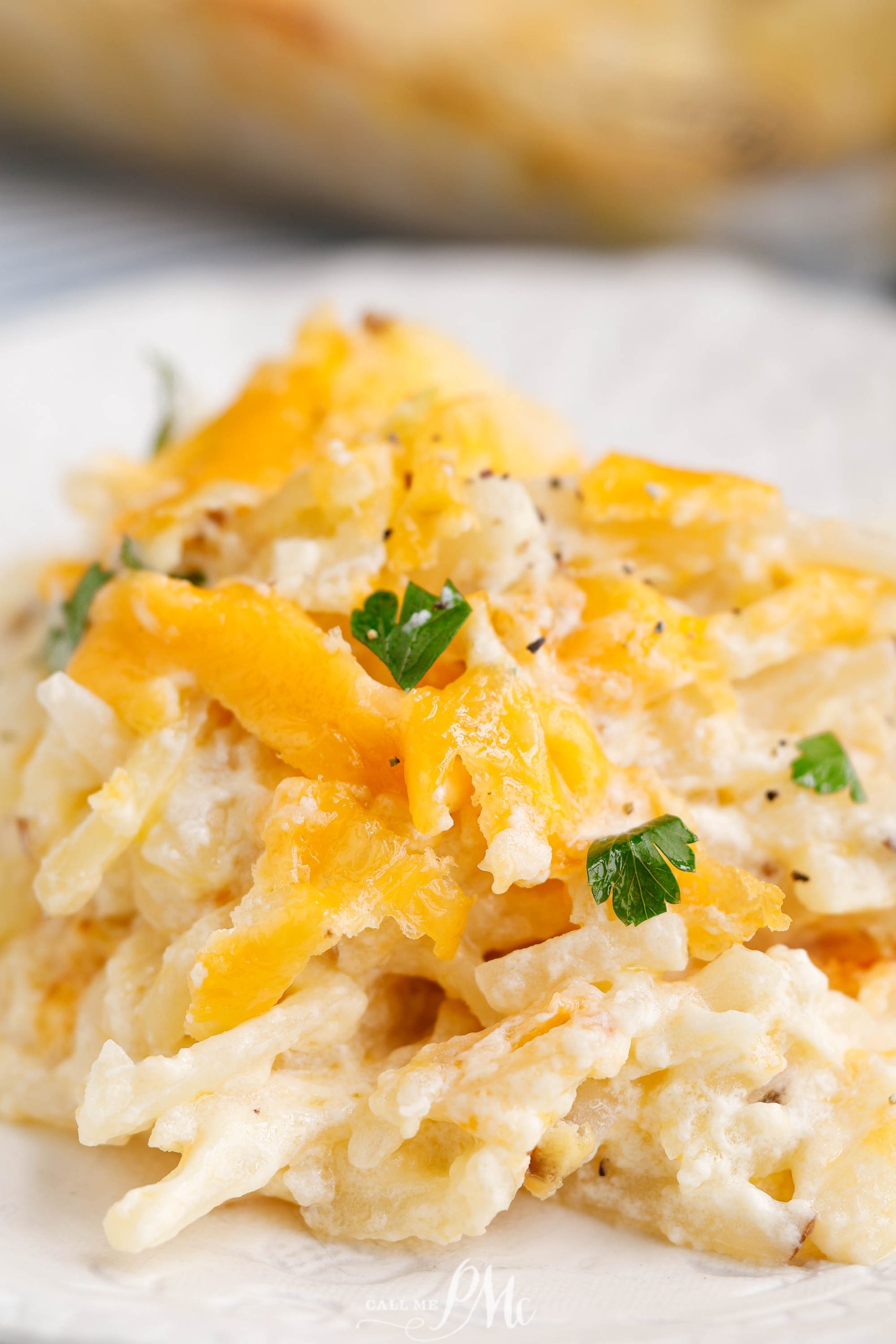 Serving of cheesy hashbrowns on a plate.