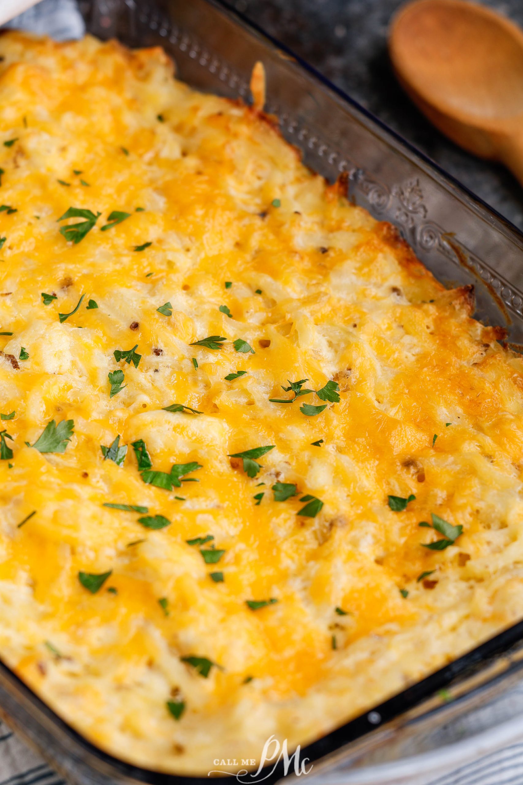 Serving of cheesy hashbrown casserole on a plate.