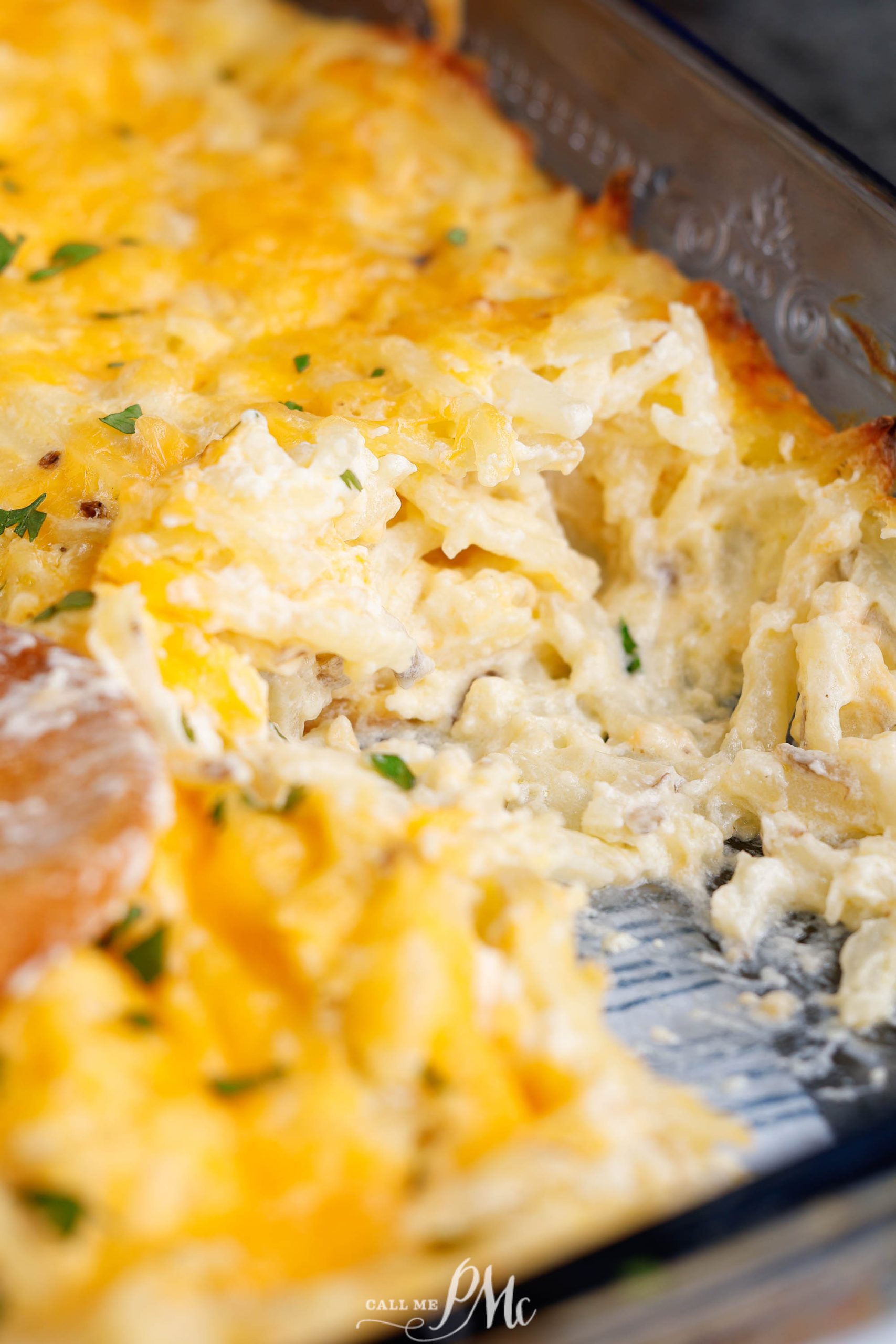 Cheesy hashbrown casserole in a pan.