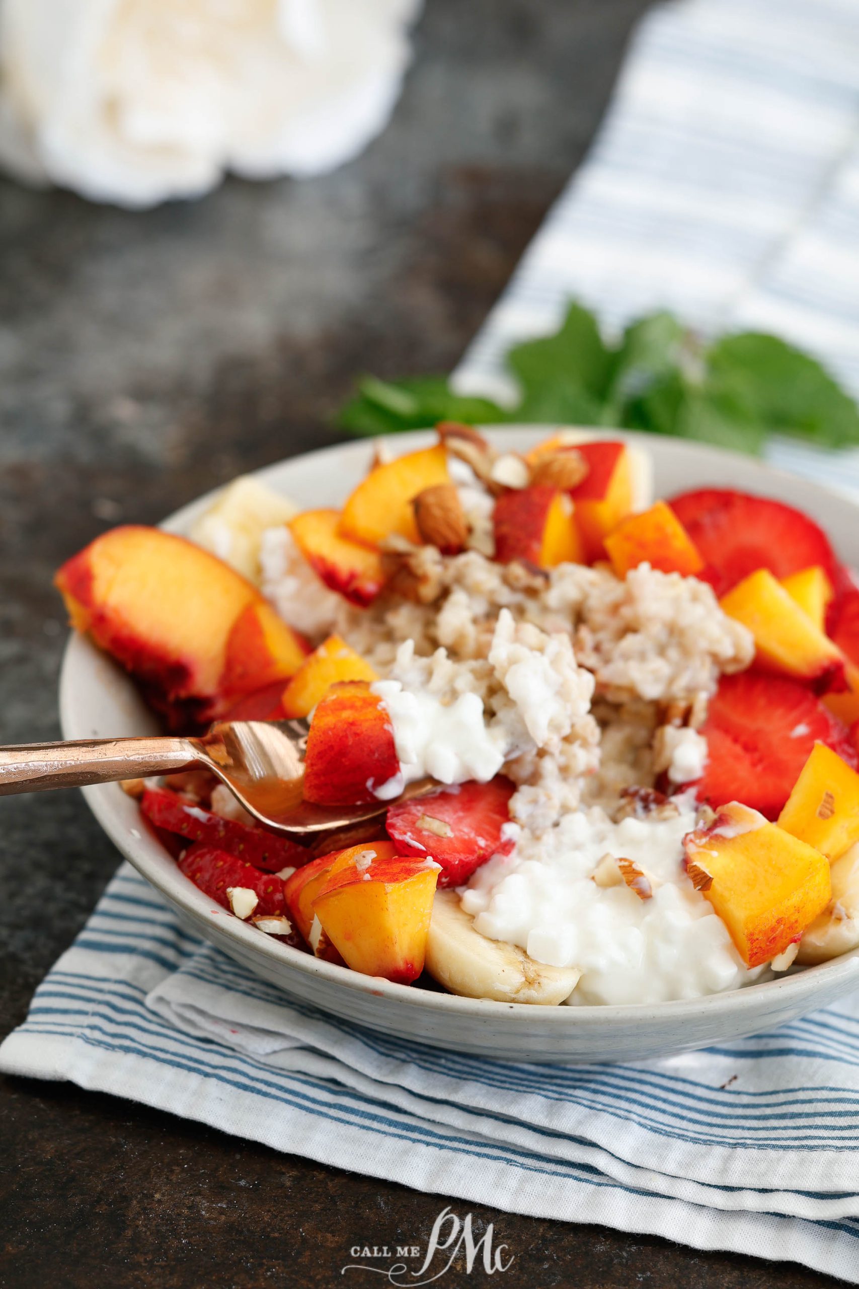 A bowl of breakfast banana split with a spoon.