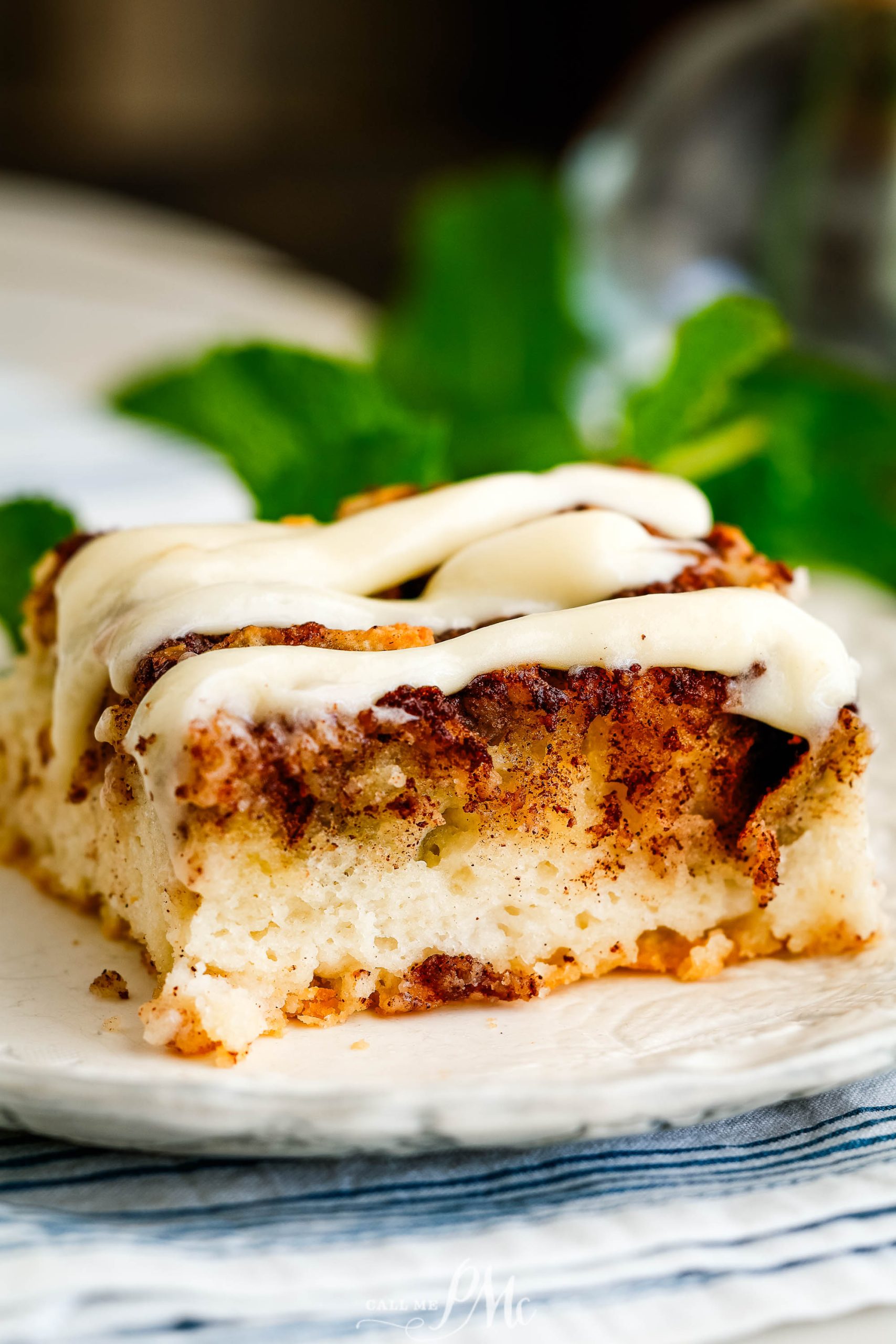 A piece of cinnamon roll cake on a plate.