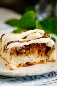 A piece of cinnamon roll cake on a plate.