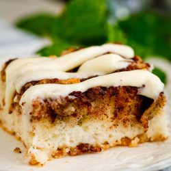 A piece of cinnamon roll cake on a plate.