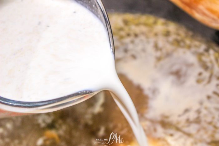 A person pouring milk into a pan.