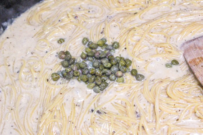 A pot of pasta with peas in it.