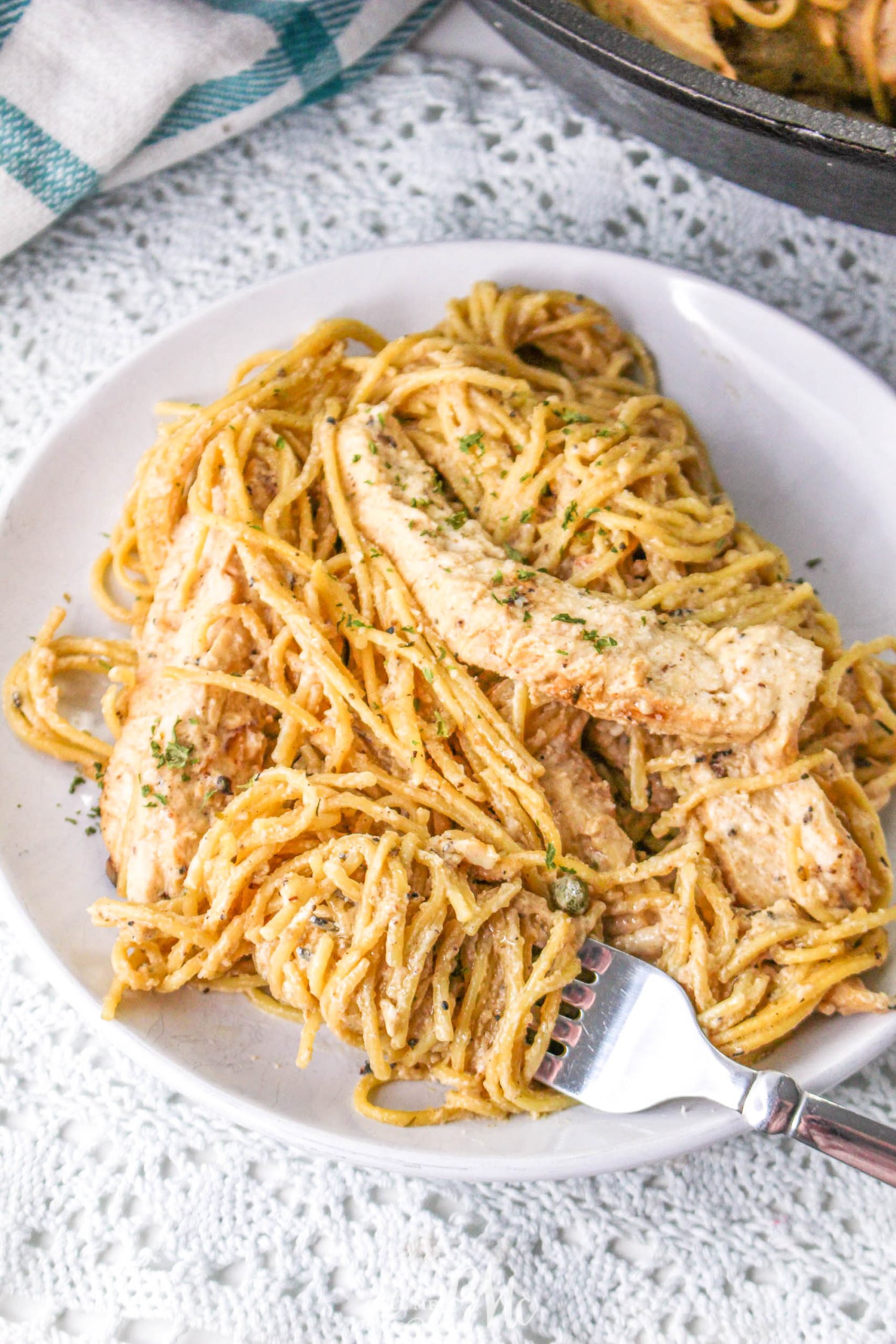 A plate of spaghetti with chicken on it.