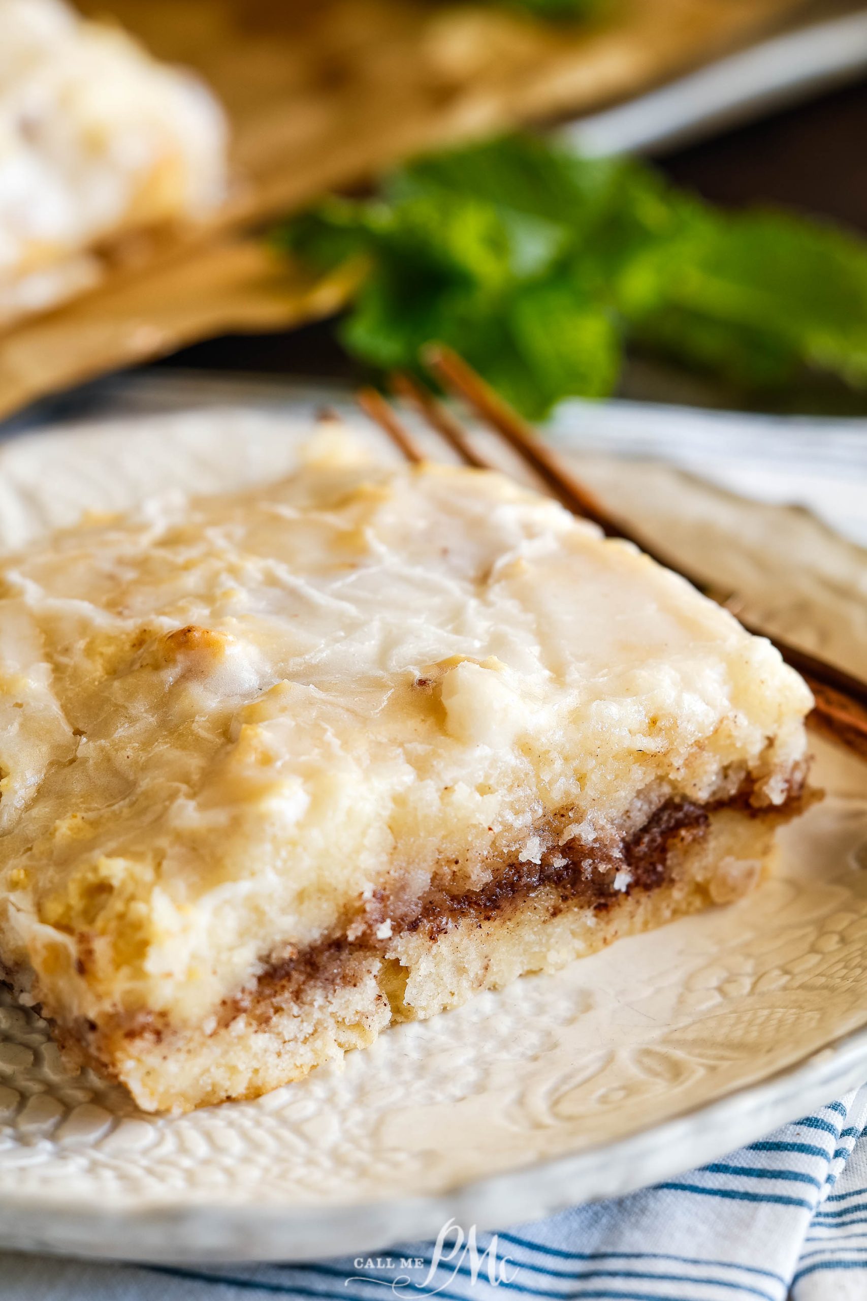 A cinnamon roll on a plate with a fork.