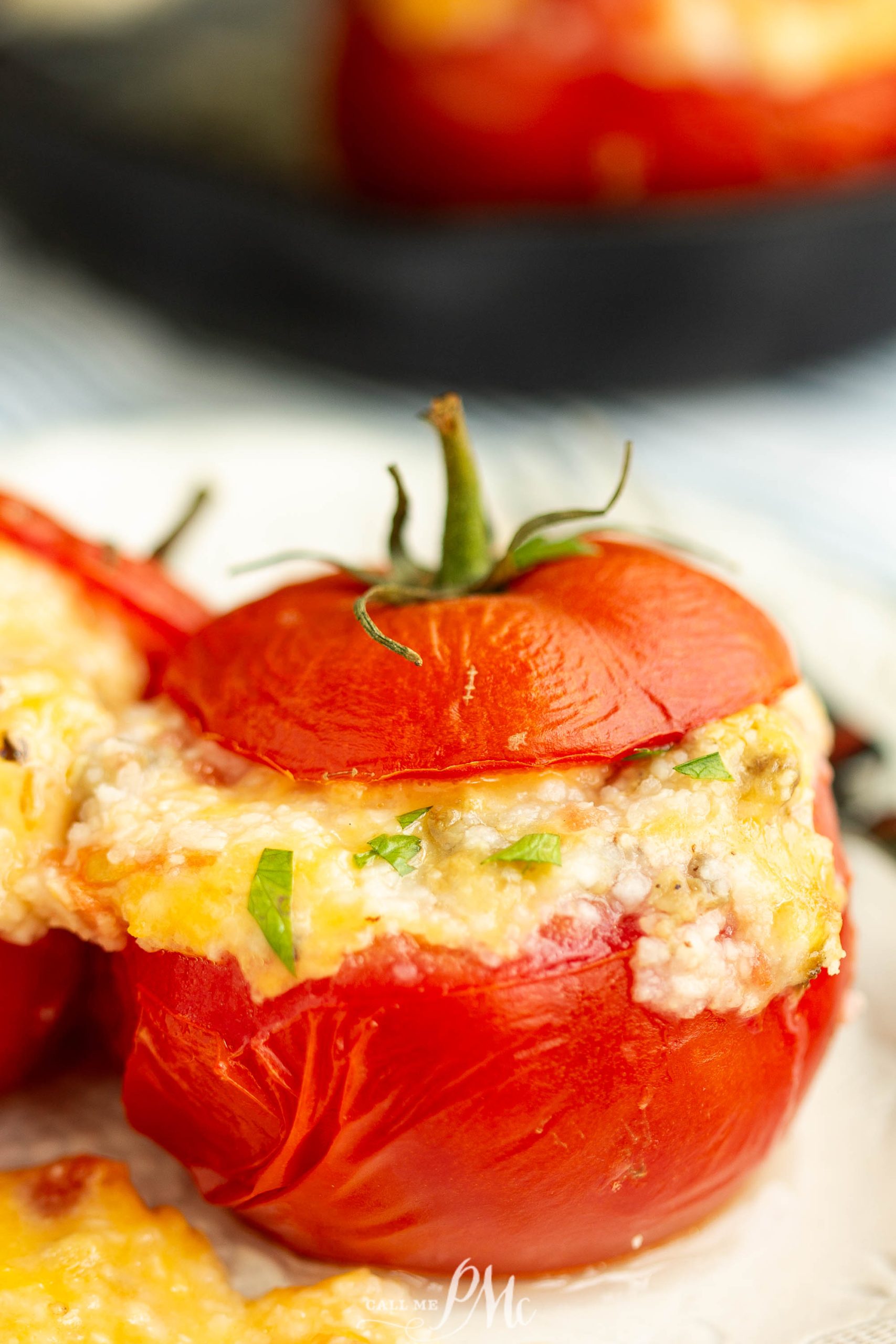 Stuffed tomatoes with cheese on a plate.