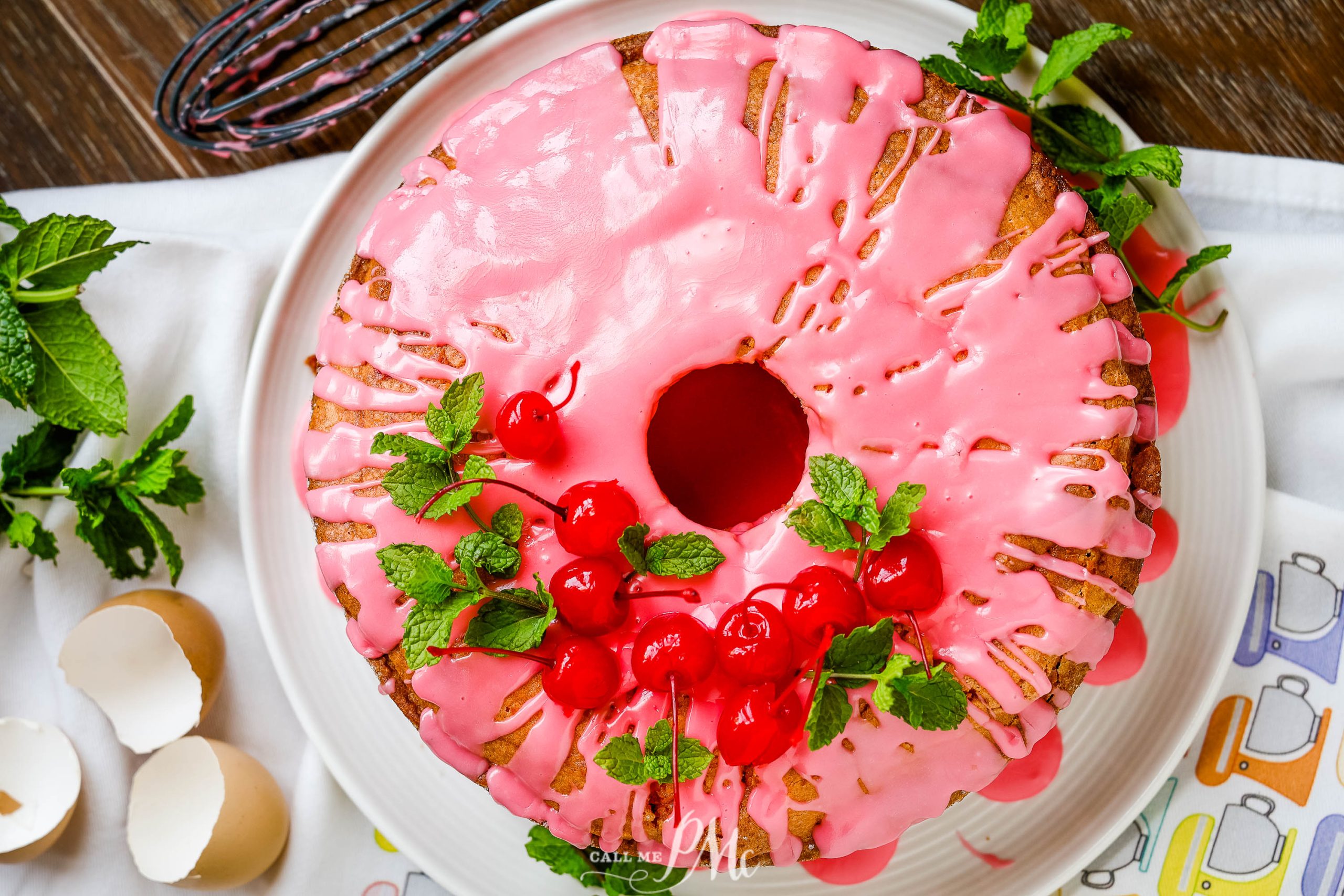 Flatlay of wohle pound cake with pink frosting.