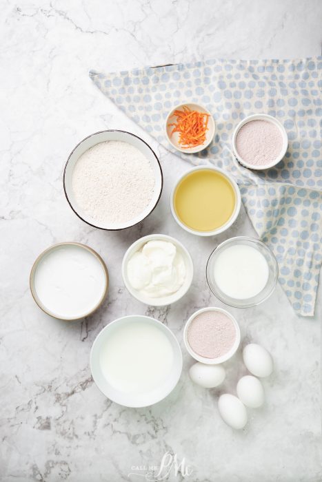 Ingredients for a carrot cake on a marble table.