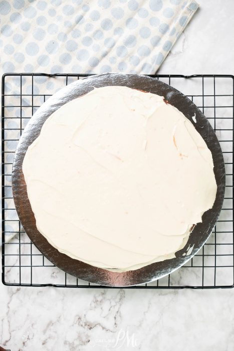 A white cake sitting on a cooling rack.