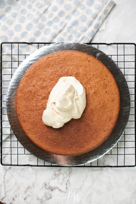 Semi Naked Orange Cake. A cake on a cooling rack with whipped cream on top.