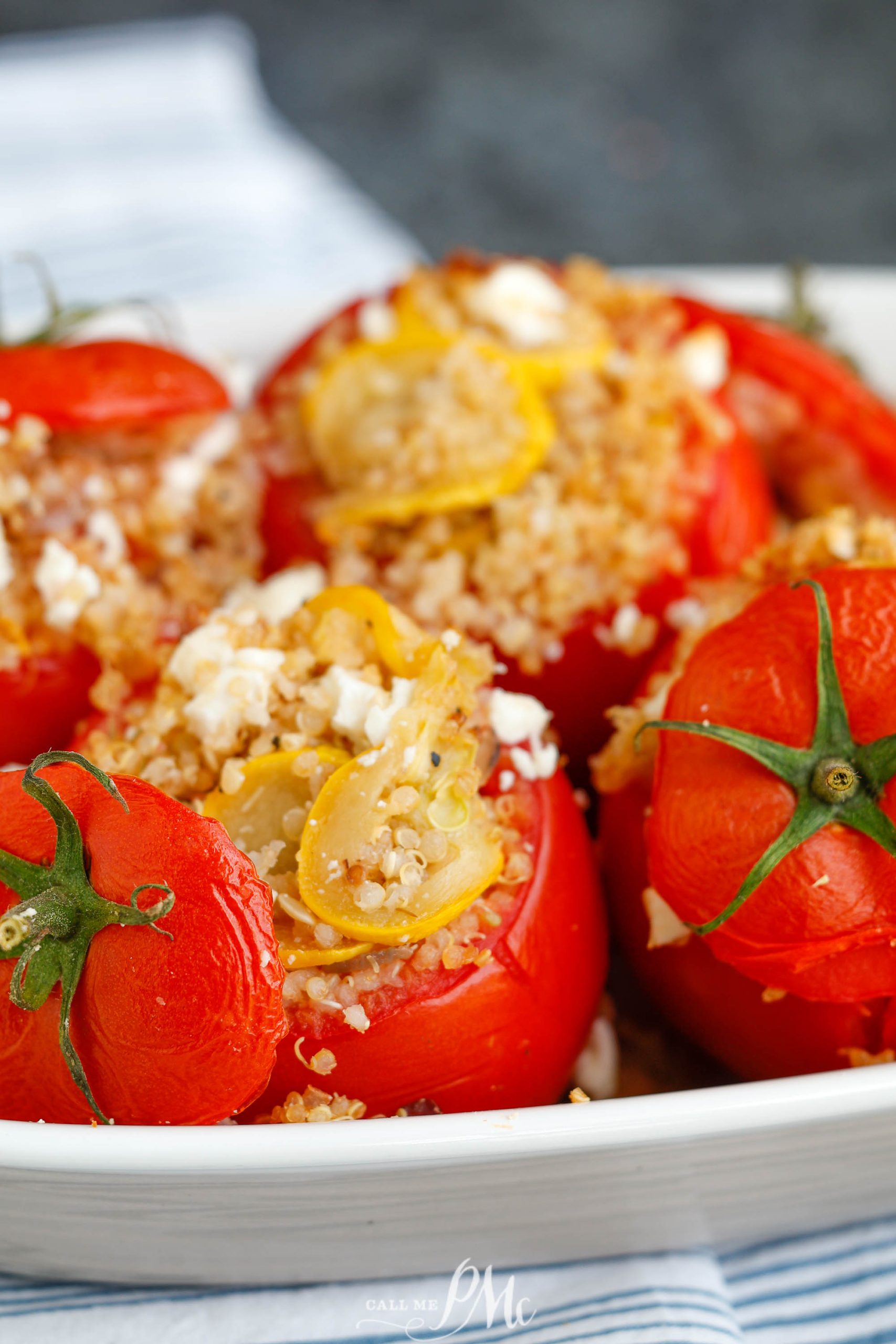 Quinoa stuffed red tomatoes in a dish.