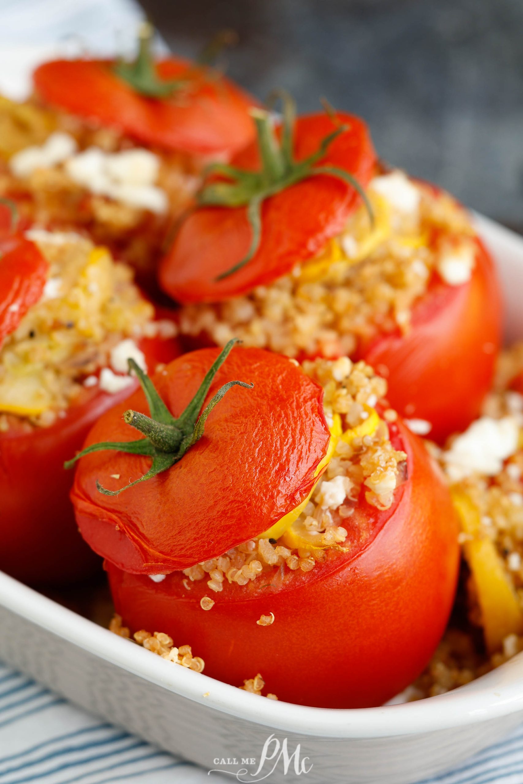 Quinoa and squash stuffed red tomatoes in a dish.