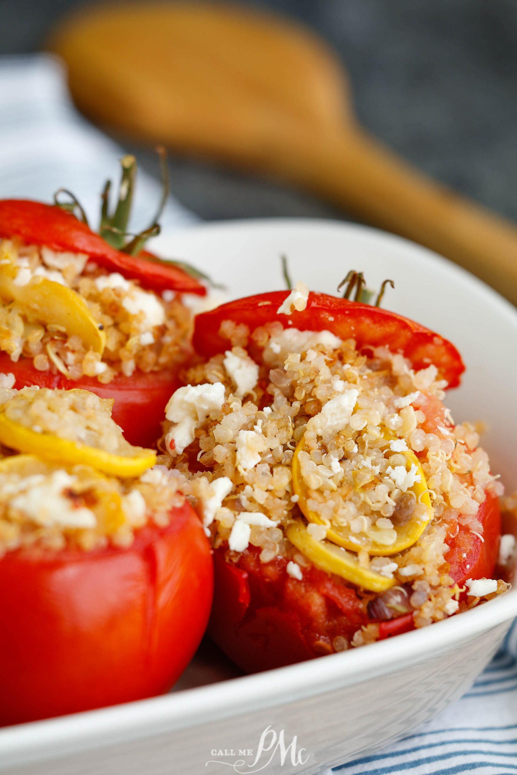 Quinoa, squash, and feta, stuffed red tomatoes in a dish.