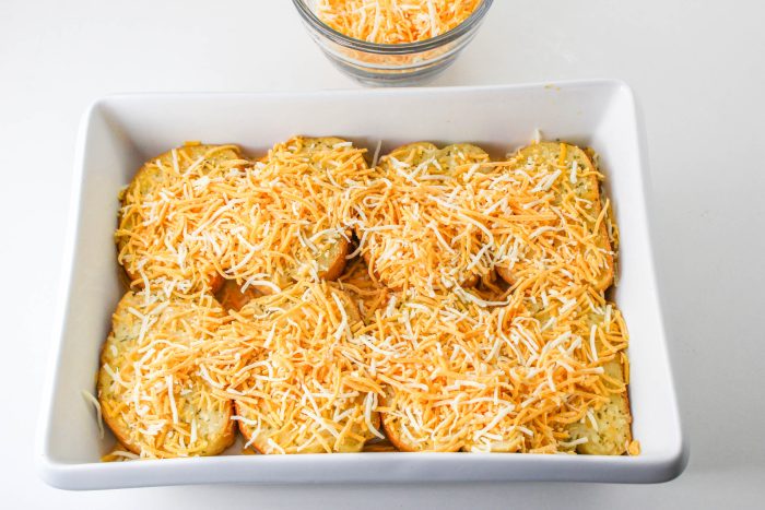 Tiktok Texas Toast Casserole with cheese on it and a glass next to it.