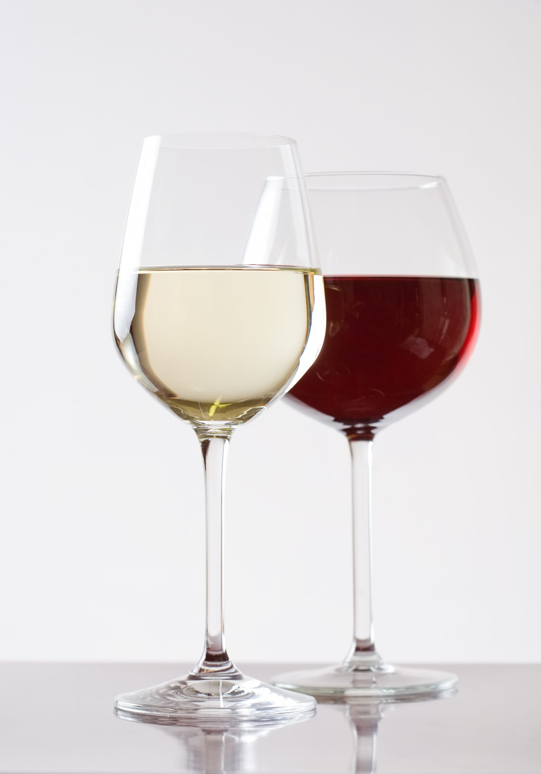 Two glasses of wine on a table with a white background.