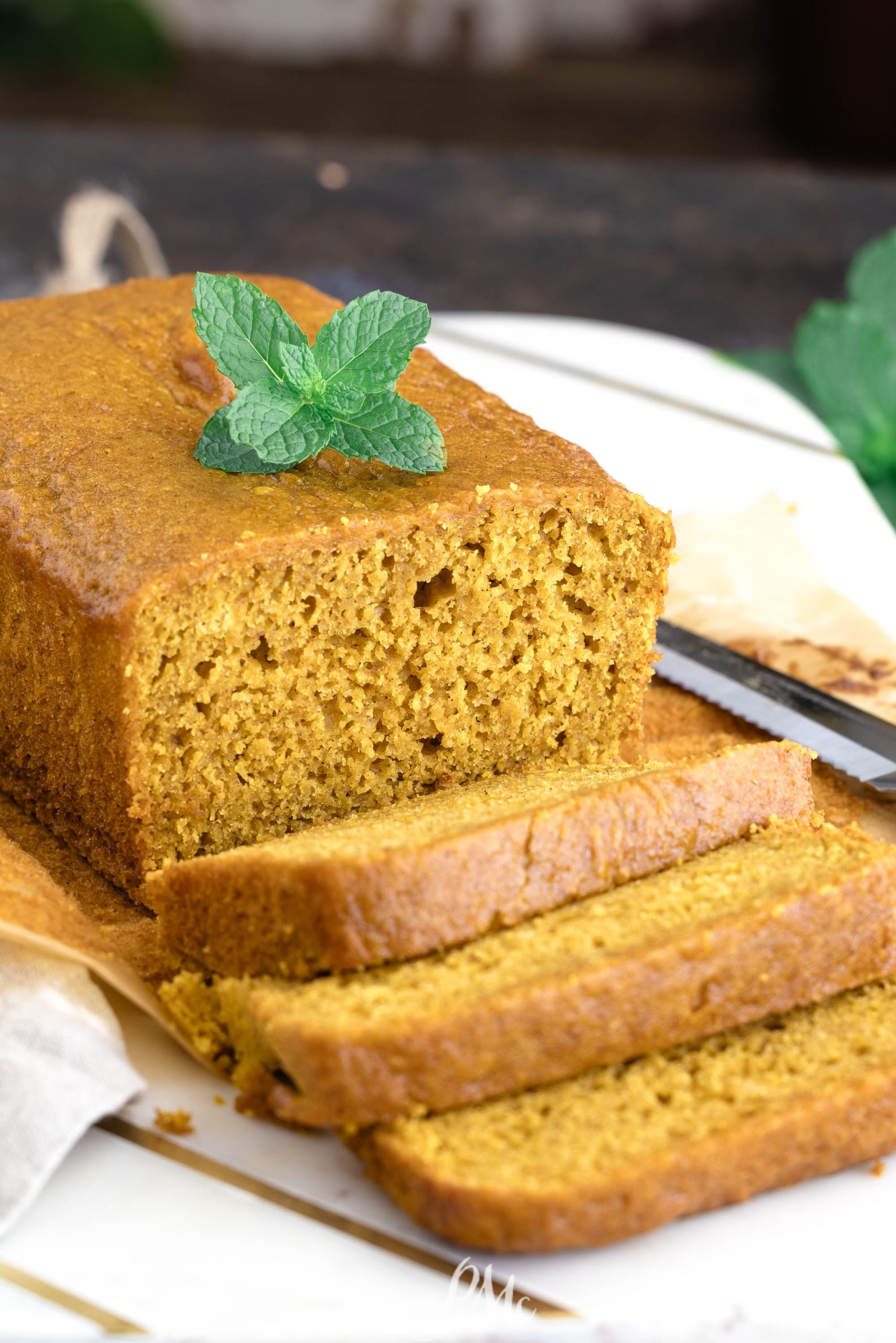 Cake Mix Pumpkin Loaf with mint leaves on a white plate.