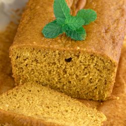 A slice of pumpkin bread with a mint leaf on top.