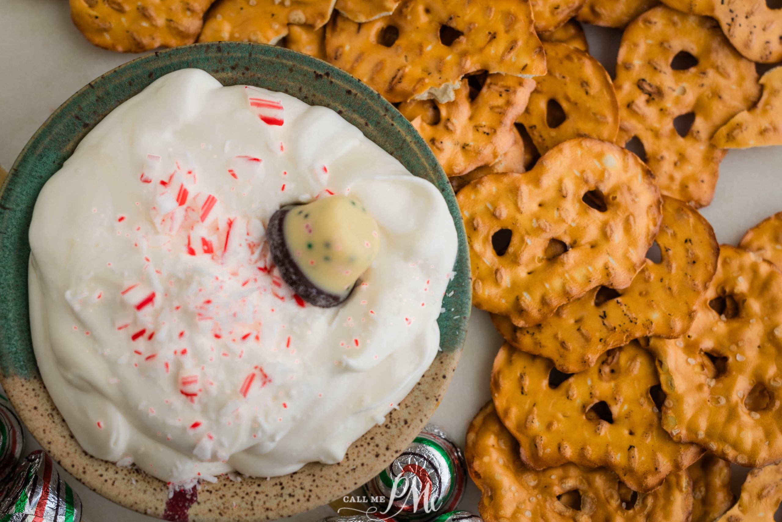 A bowl of peppermint dip with crackers and candy canes.