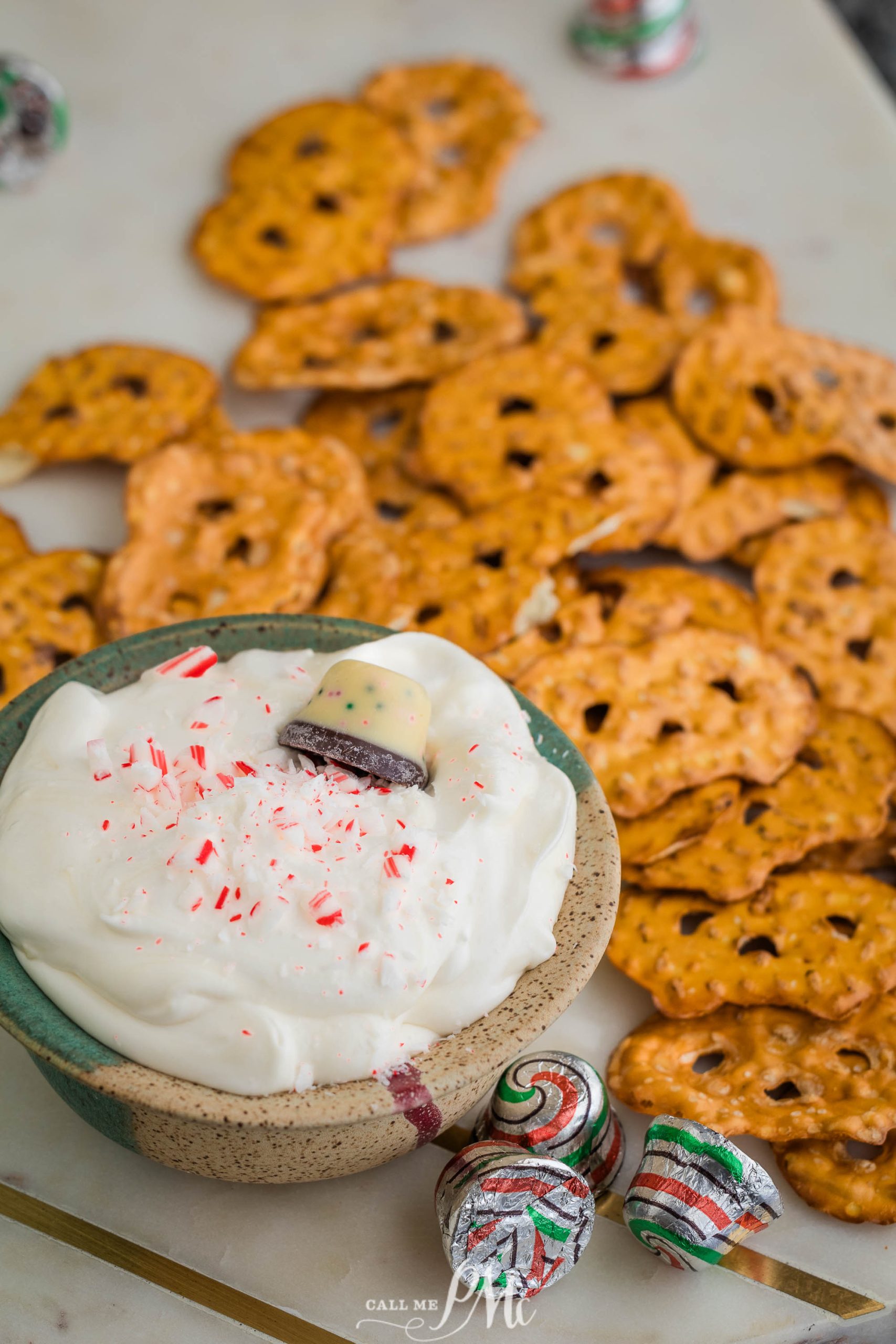 A bowl of pretzel dip surrounded by candy canes.