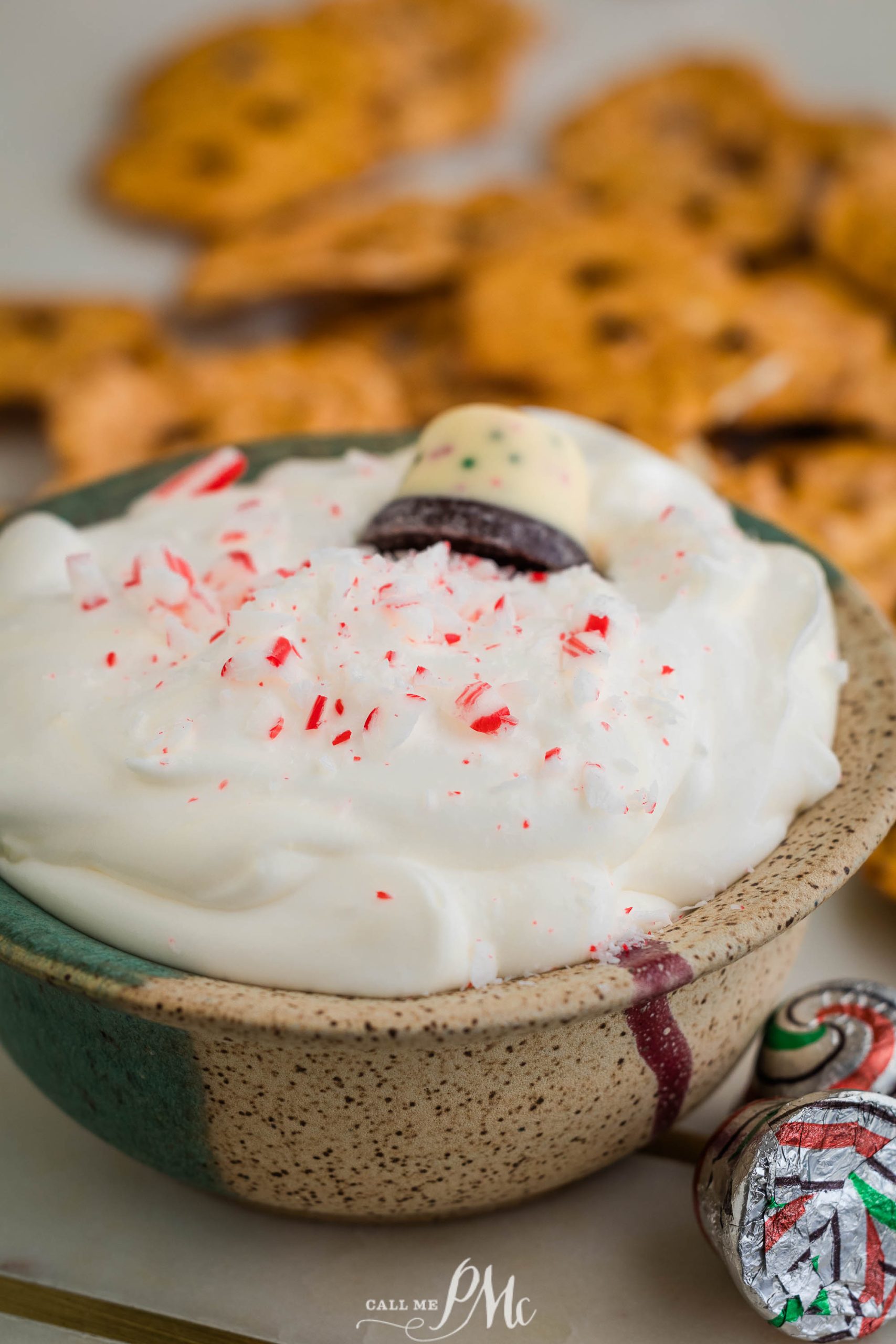 A bowl with whipped cream and peppermint chips.