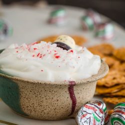 A bowl of peppermint whipped cream with candy canes.