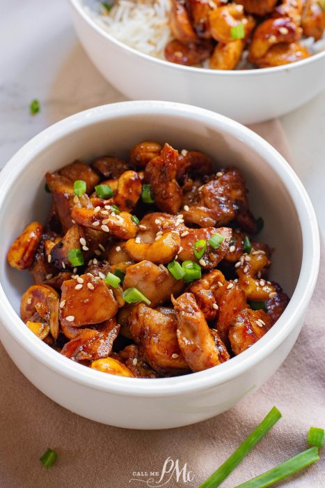 Two bowls of chicken and rice on a table.