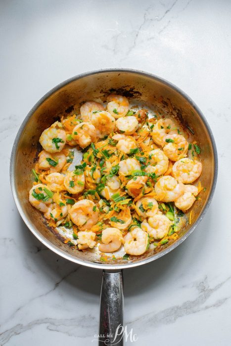 Fried shrimp in a frying pan on a marble countertop.