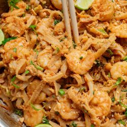 Thai shrimp pad thai in a pan with chopsticks.