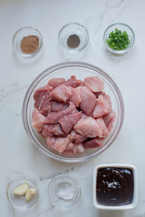 A bowl of ingredients for pork tenderloin on a marble counter.