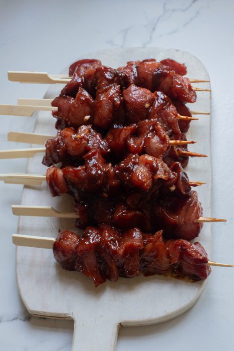 Pork skewers on skewers on a wooden board.