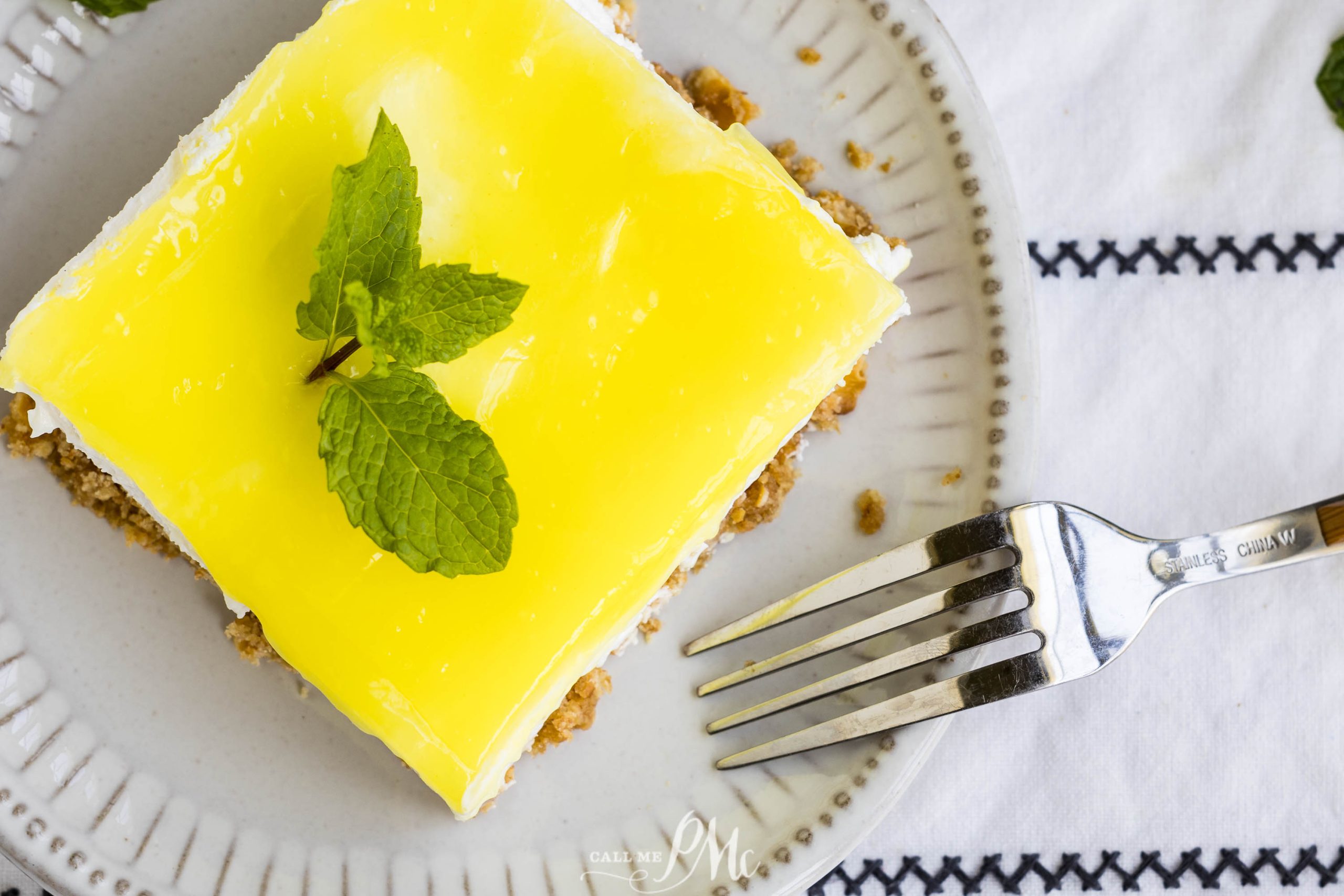 A slice of lemon cake on a plate with a fork.