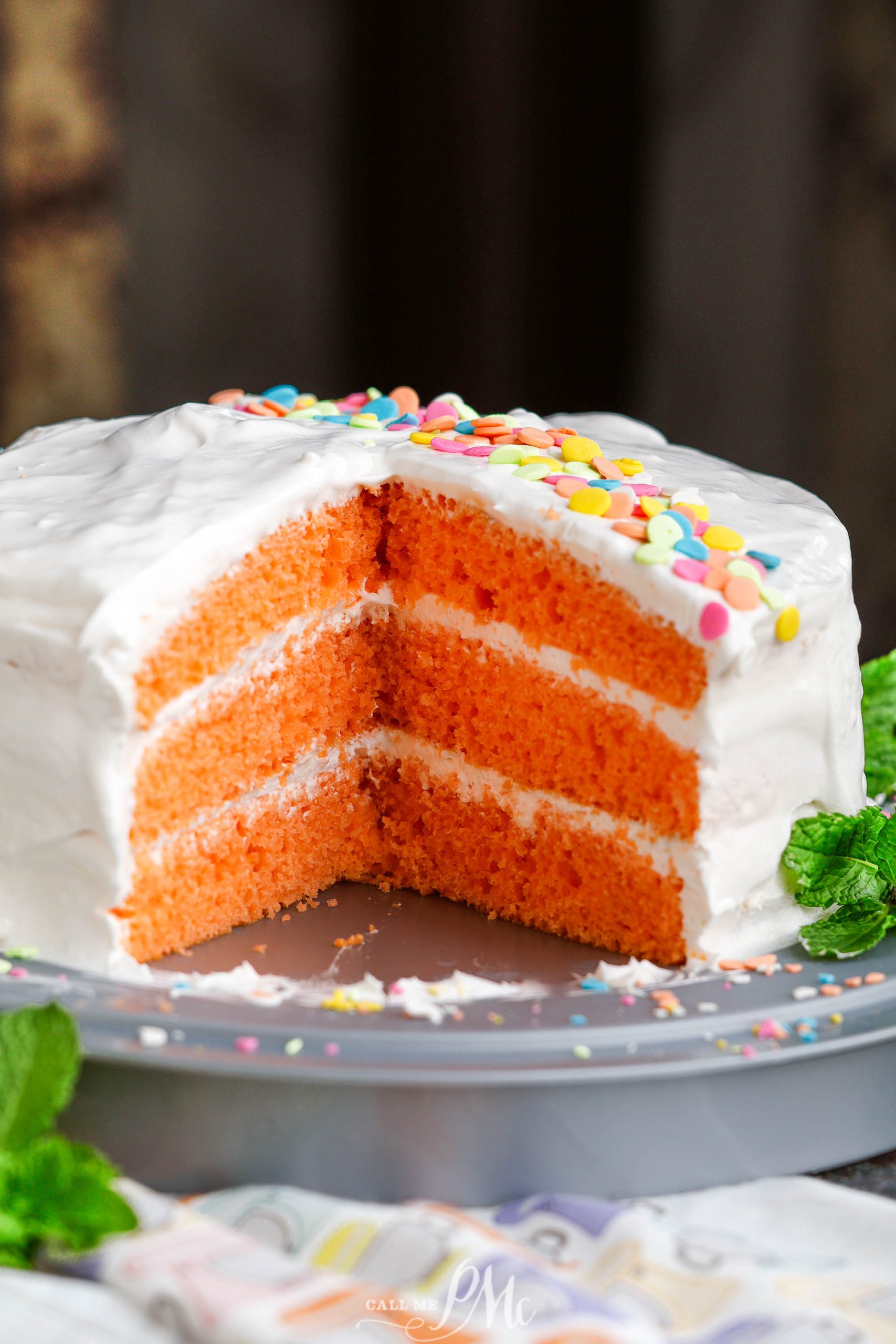 An orange cake with a slice taken out.