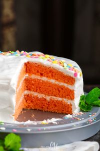 A slice of orange cake on a plate.