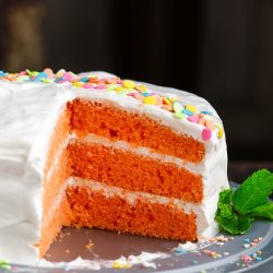 A slice of orange cake on a plate.