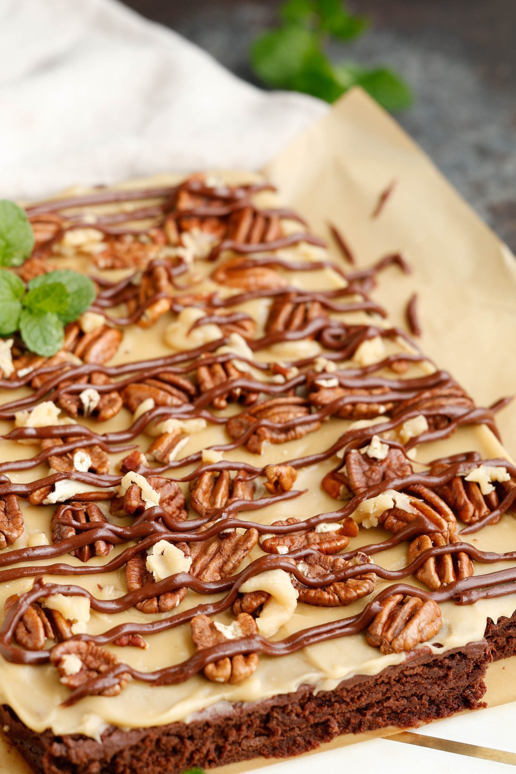 A brownie covered in chocolate and pecans.