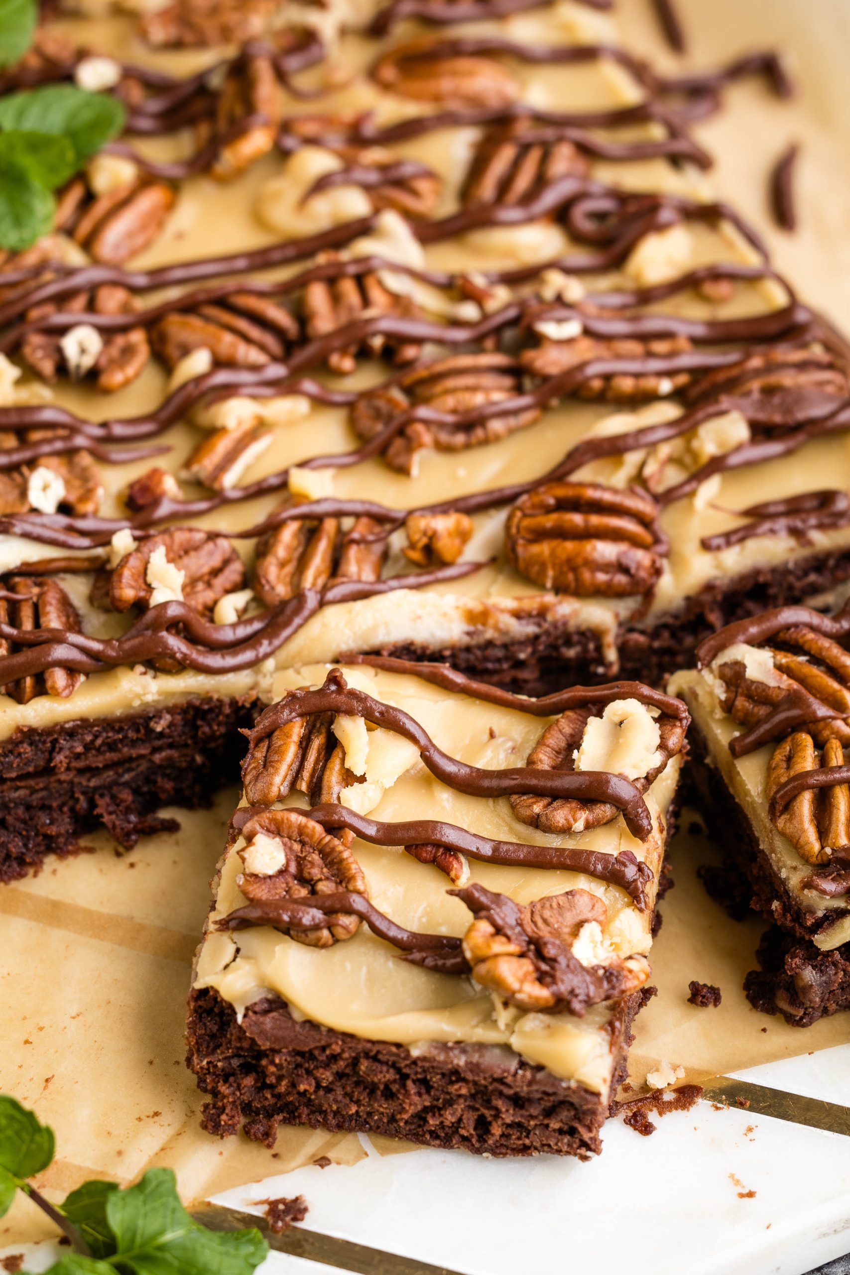 A piece of chocolate brownie with pecans and a drizzle of peanut butter.