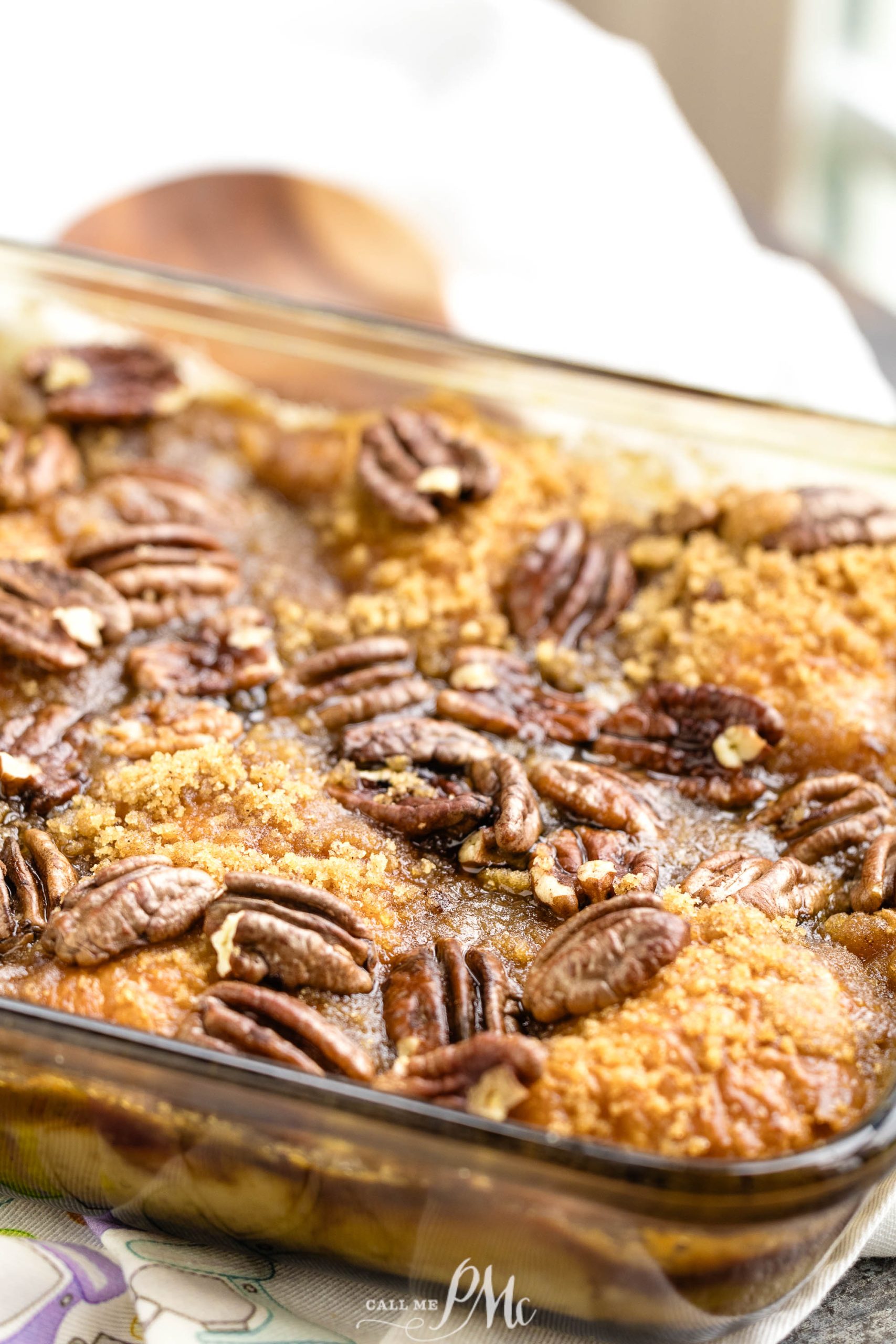 Praline Croissant Bread Pudding in a glass dish with pecans.