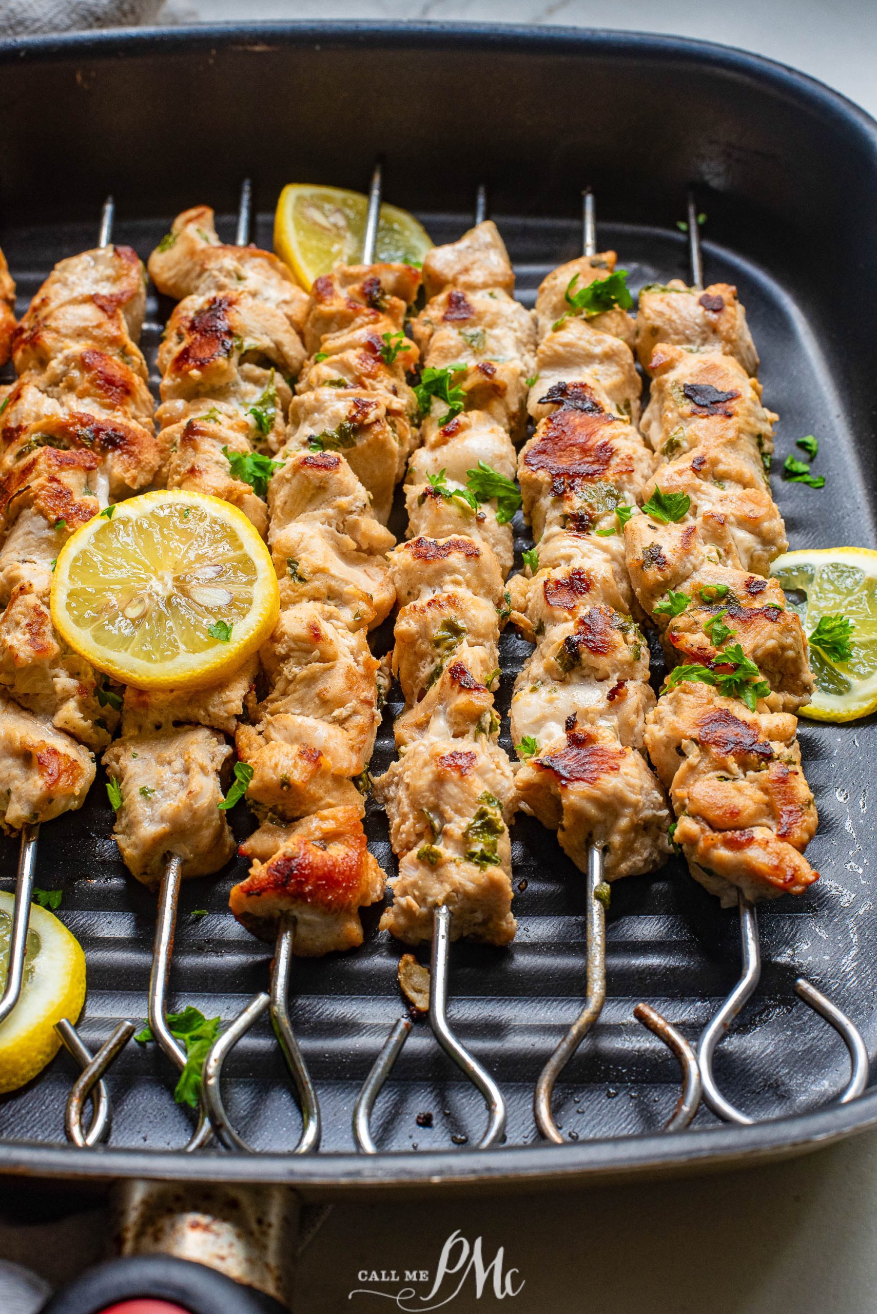 🎉Stovetop Chicken Souvlaki in a pan with lemon wedges.