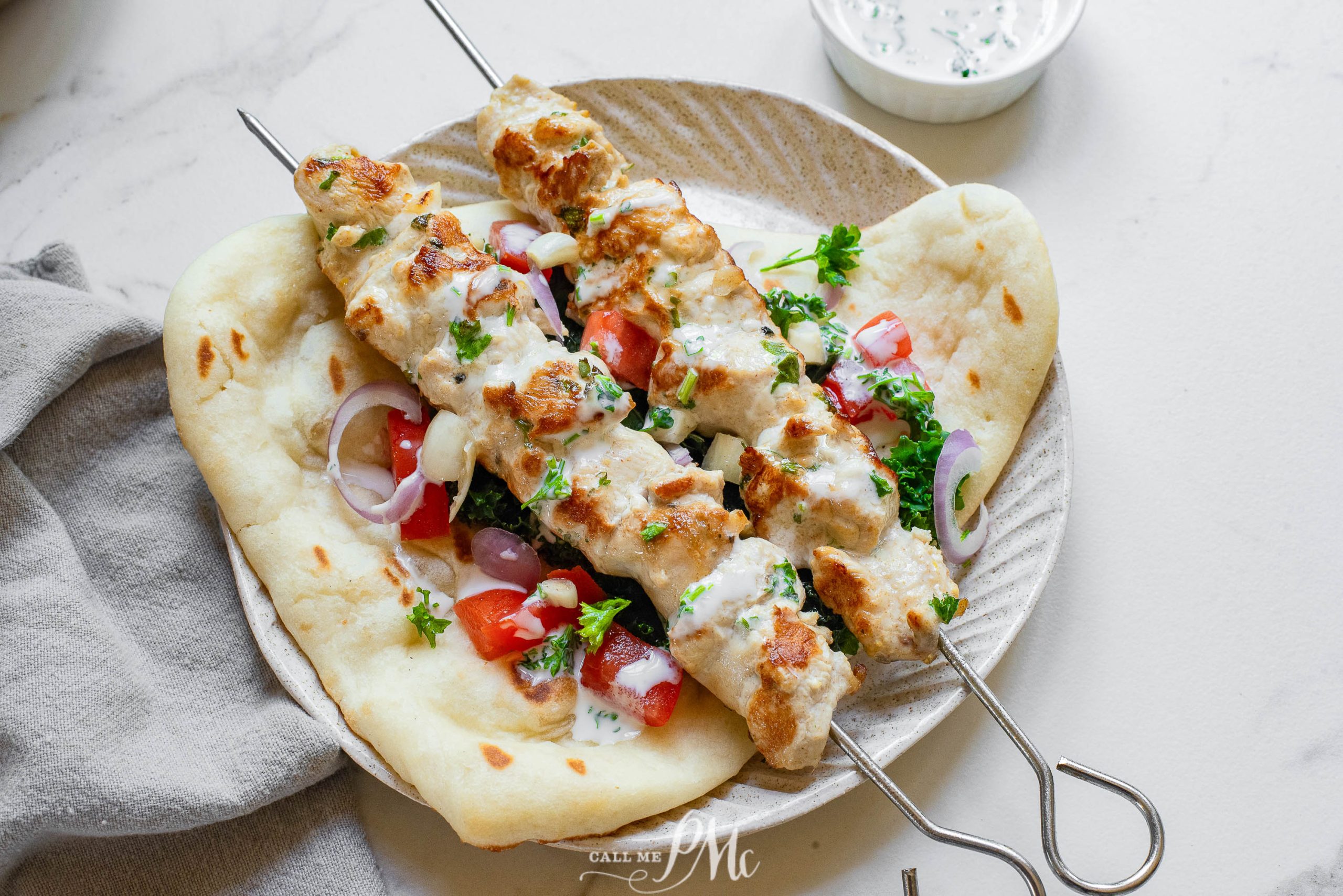 Chicken souvlaki with tzatziki sauce on a plate.