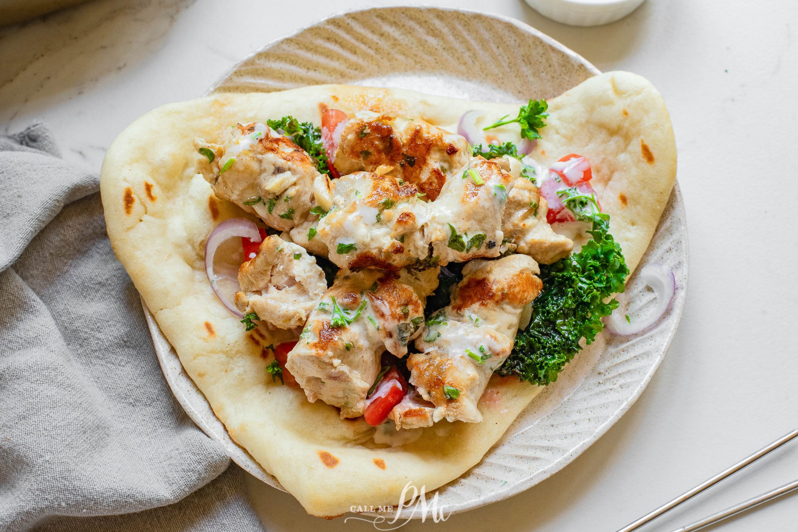 Chicken Souvlaki with Naan on a white plate.