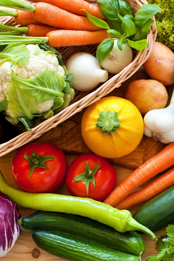 A basket full of vegetables on a table.