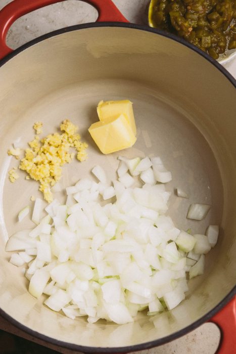 Onions and butter in a pan on a table.