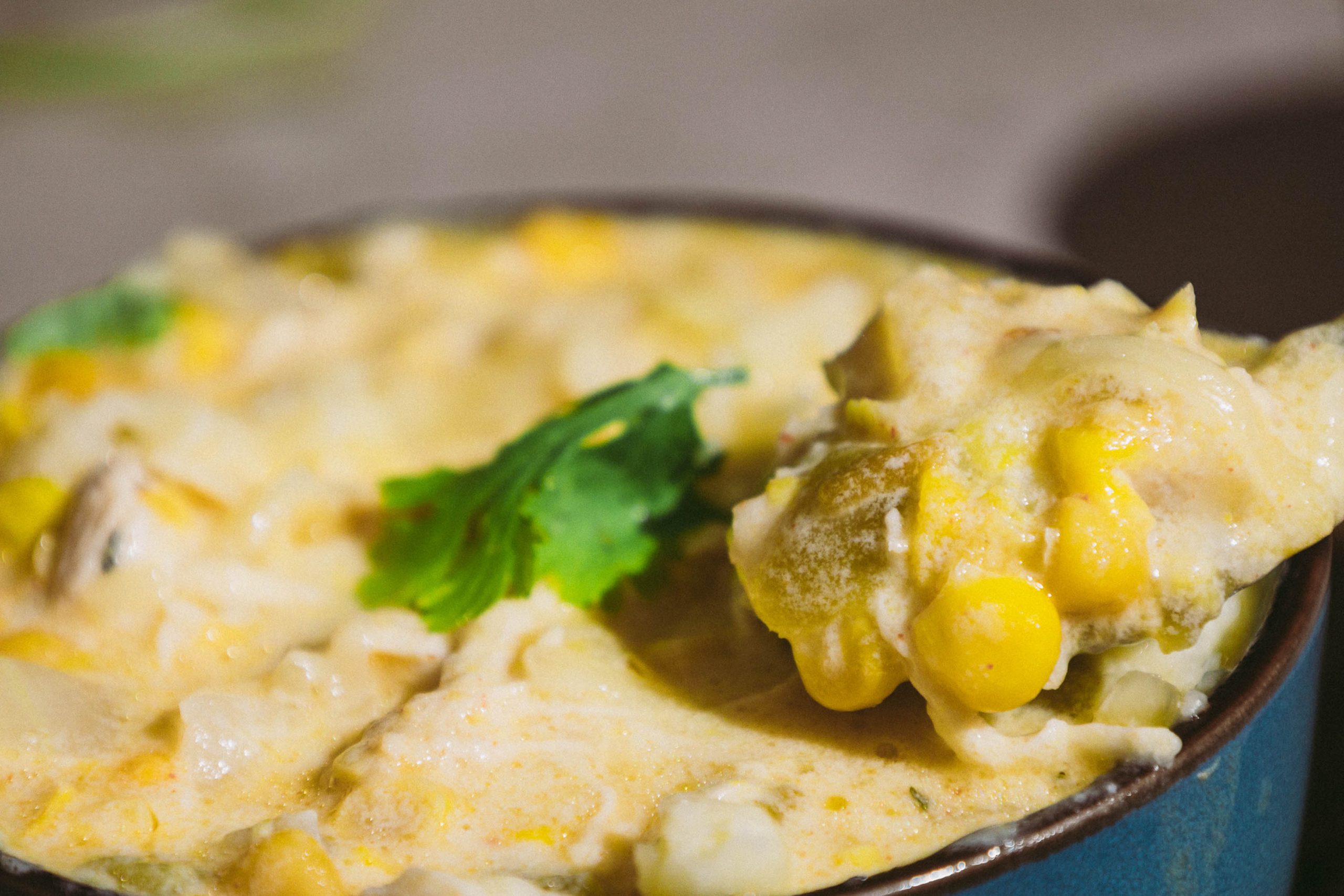 A bowl of Green Chili Chicken Corn Chowderwith a spoon.